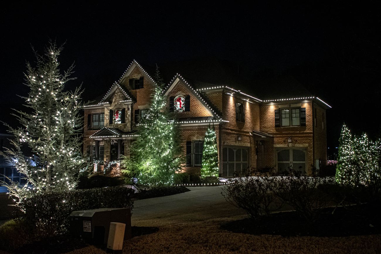 Lit evergreens, wreaths and a full front elevation