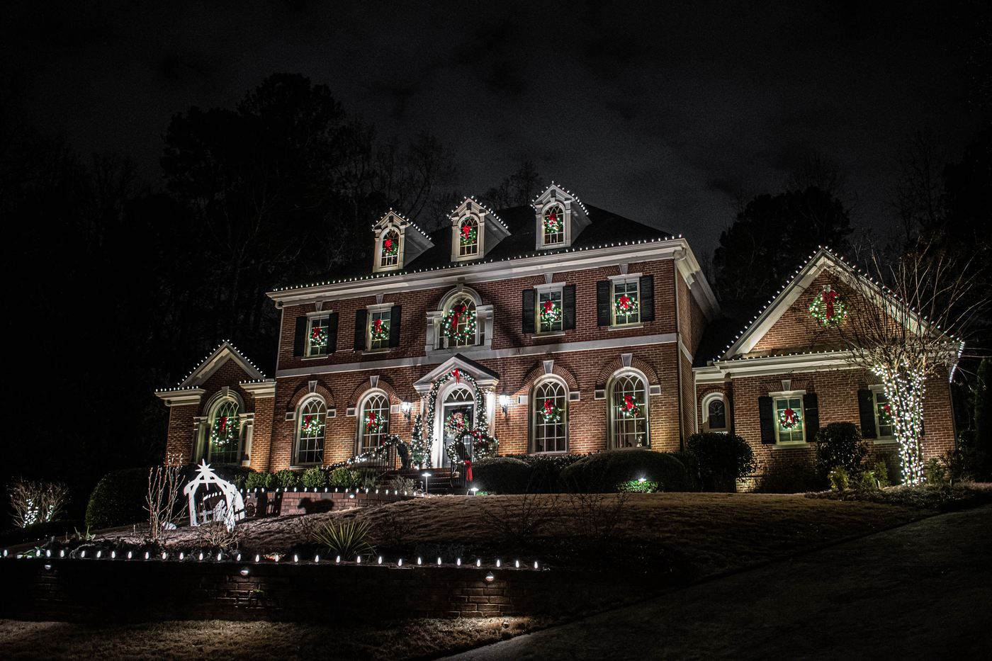Red ribbon, garland at the entry and lit beds along the walk